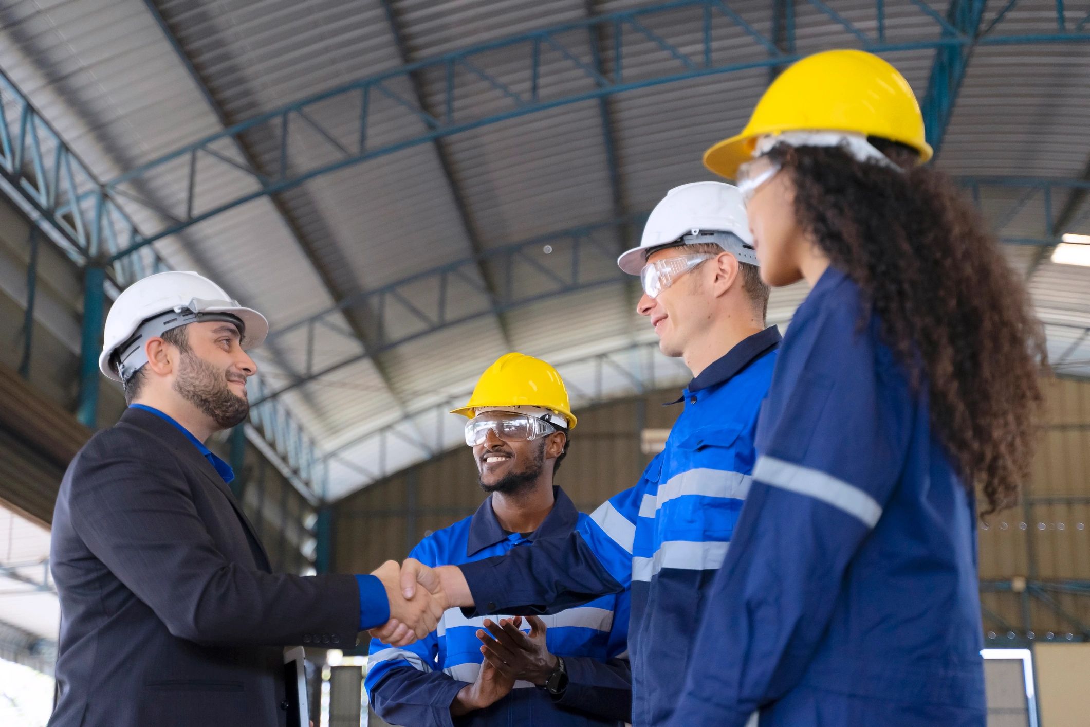 Engineering team working in a factory with robotic arms